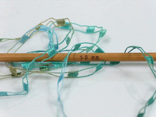 Roll of Turquoise, Green and Blue Thread and Gold Ribbon